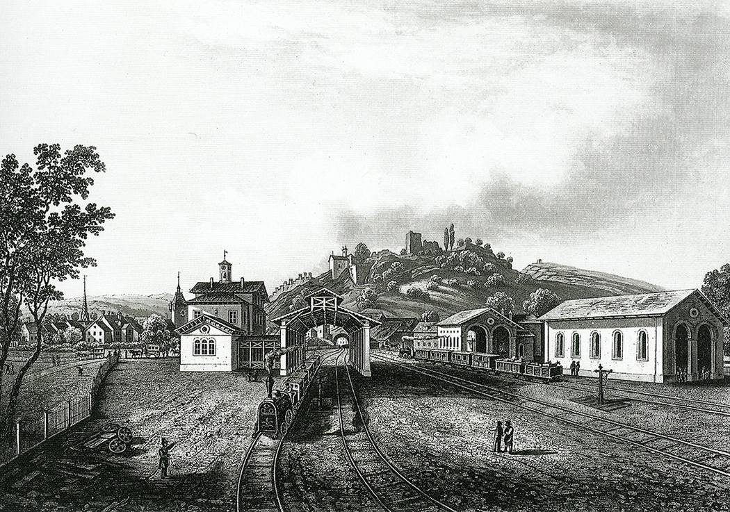 Historischer Stich des Bahnhofs Baden um 1850: Dampflokomotive mit Wagen der Spanisch-Brötli-Bahn vor Stationsgebäuden und Lokremise, im Hintergrund die Ruine Stein.